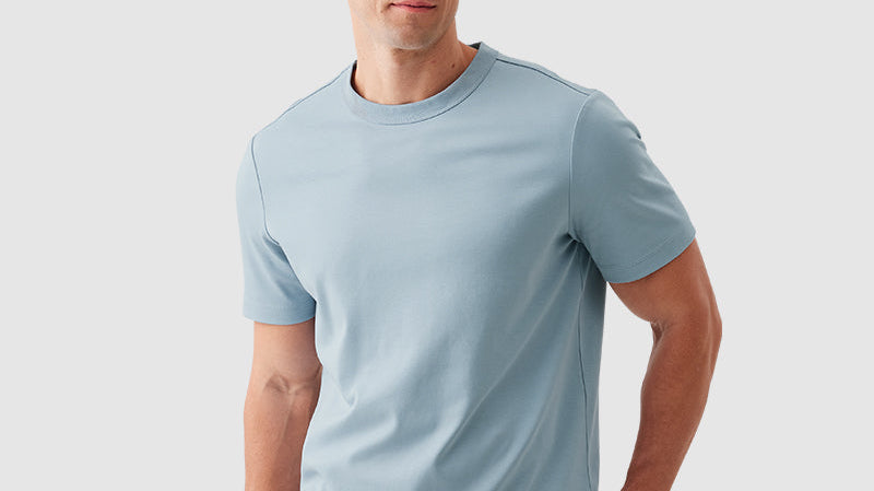 Two premium men's tees in coastal and sierra blue tones displayed in a casual lifestyle setting